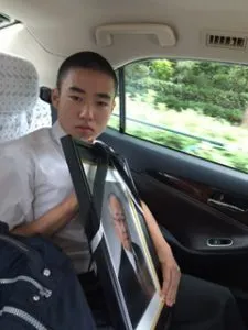 遺影を持つ息子